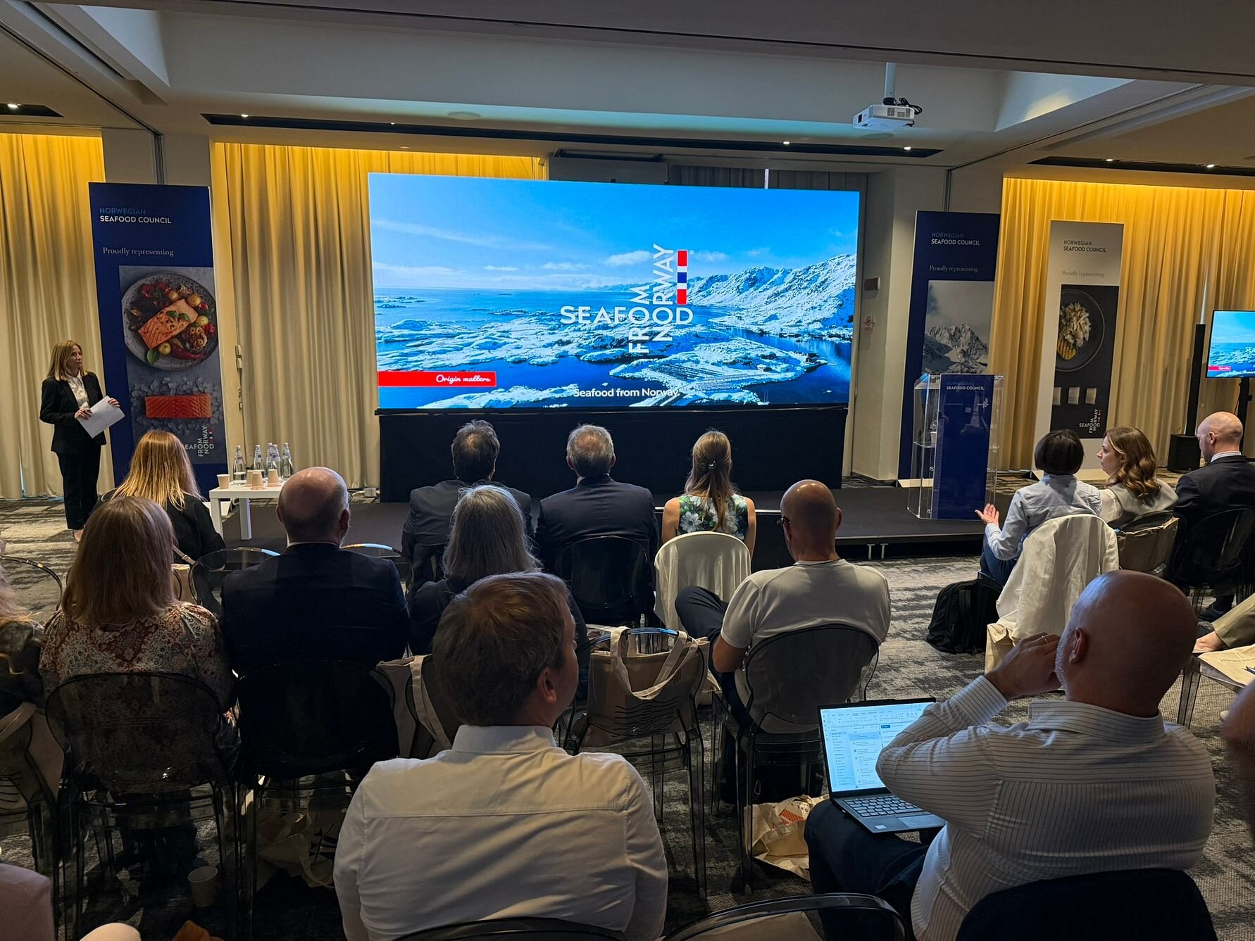 Stage and audience at seafood seminar in Italy.