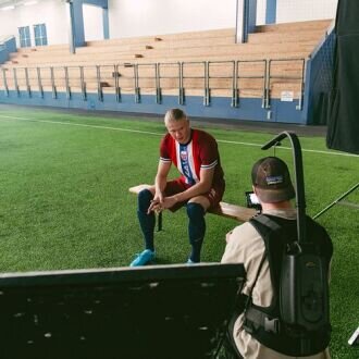 Erling Haaland behind the scenes in the Norwegian Seafood Council’s new videos, football field in the background.