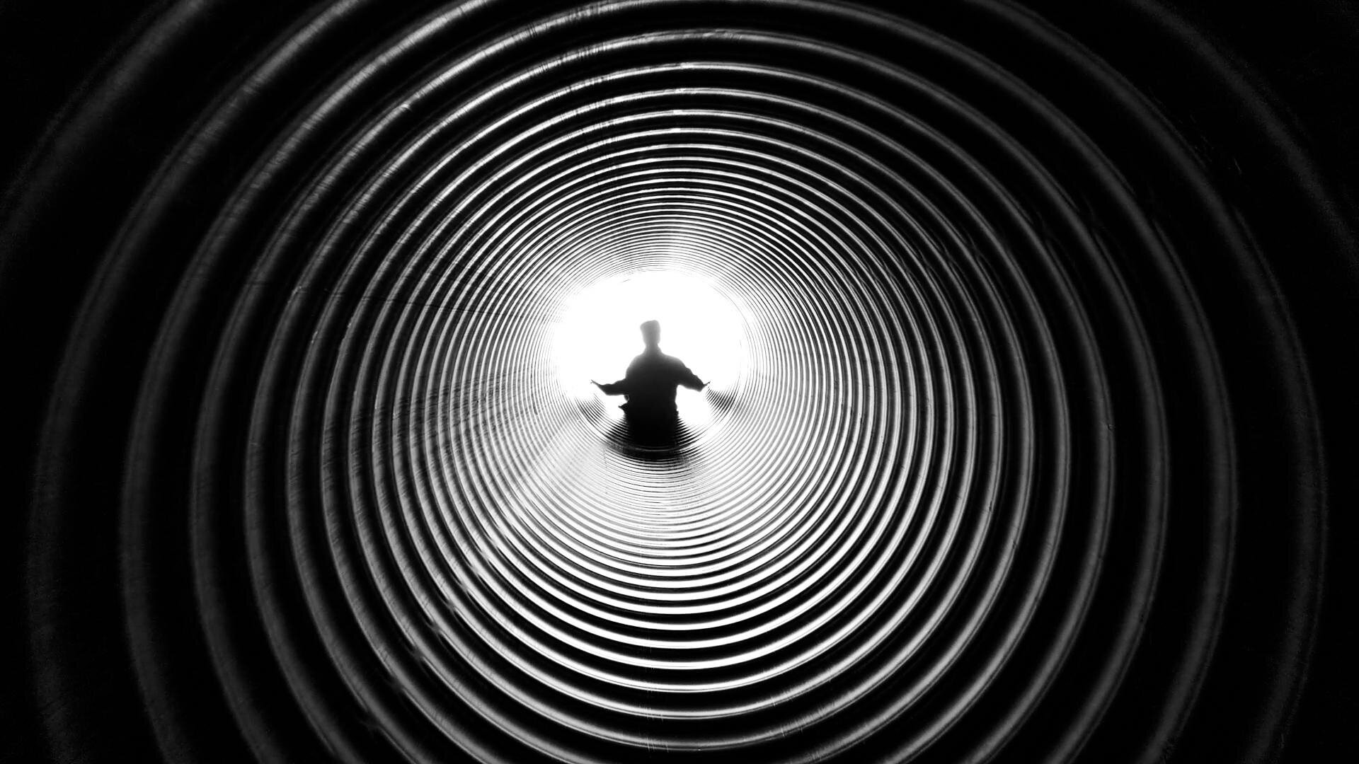 black and white image of man in a vortex.