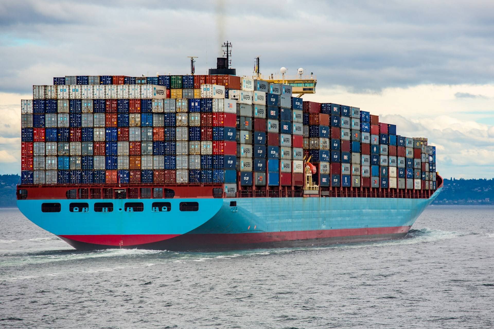 Blue and red cargo ship on sea during daytime.