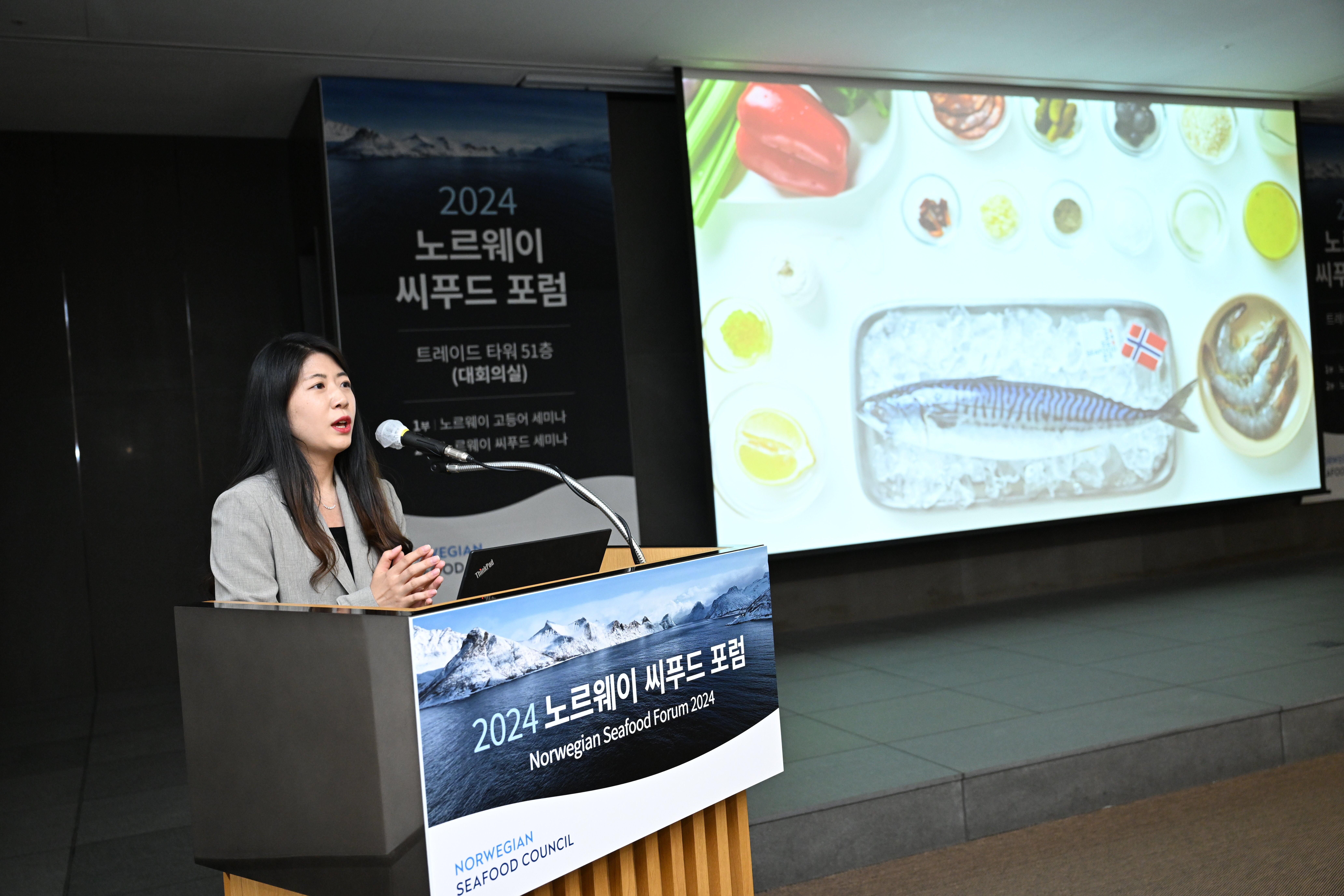 Fish in a South Korean grocery store with posters from Seafood From Norway with korean text